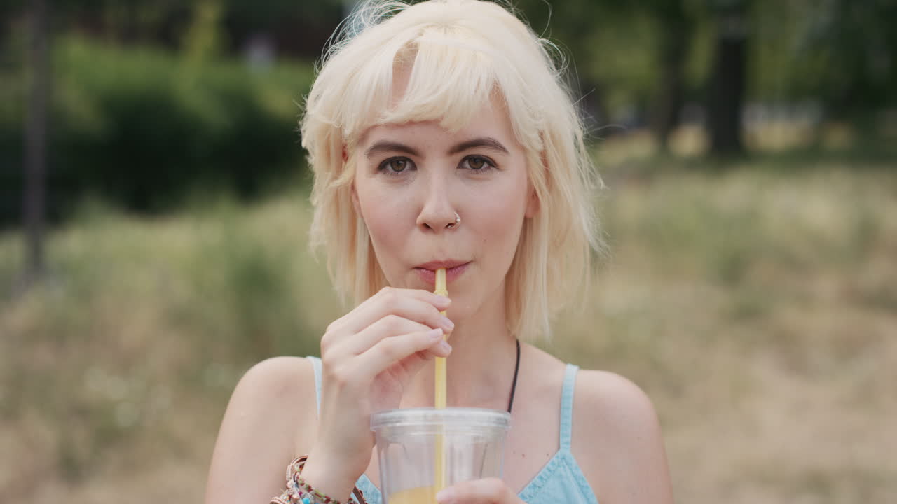 Slow Motion Portrait of happy beautiful caucasian woman drinking juice