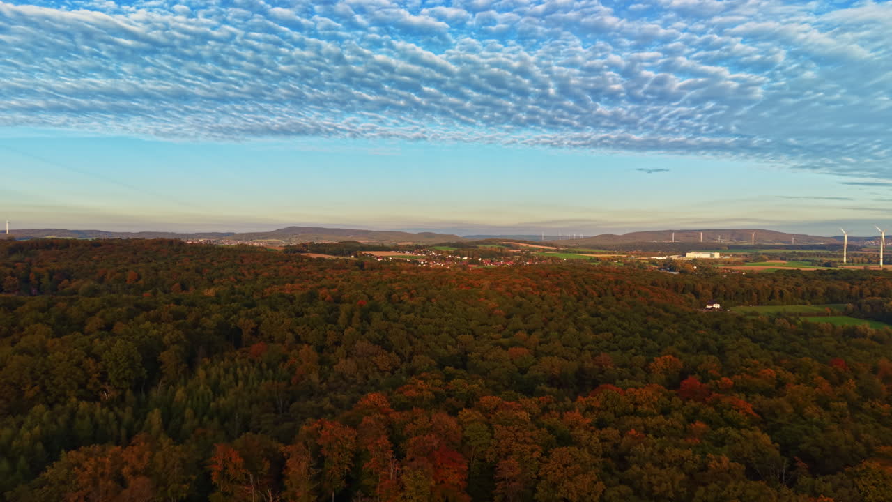Vibrante paesaggio autunnale con fogliame colorato e cielo drammatico su un tranquillo scenario rurale