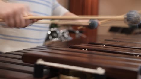 female-playing-marimba-with-mallets,-ryhthmically-hitting-bars,-closeup-side-view