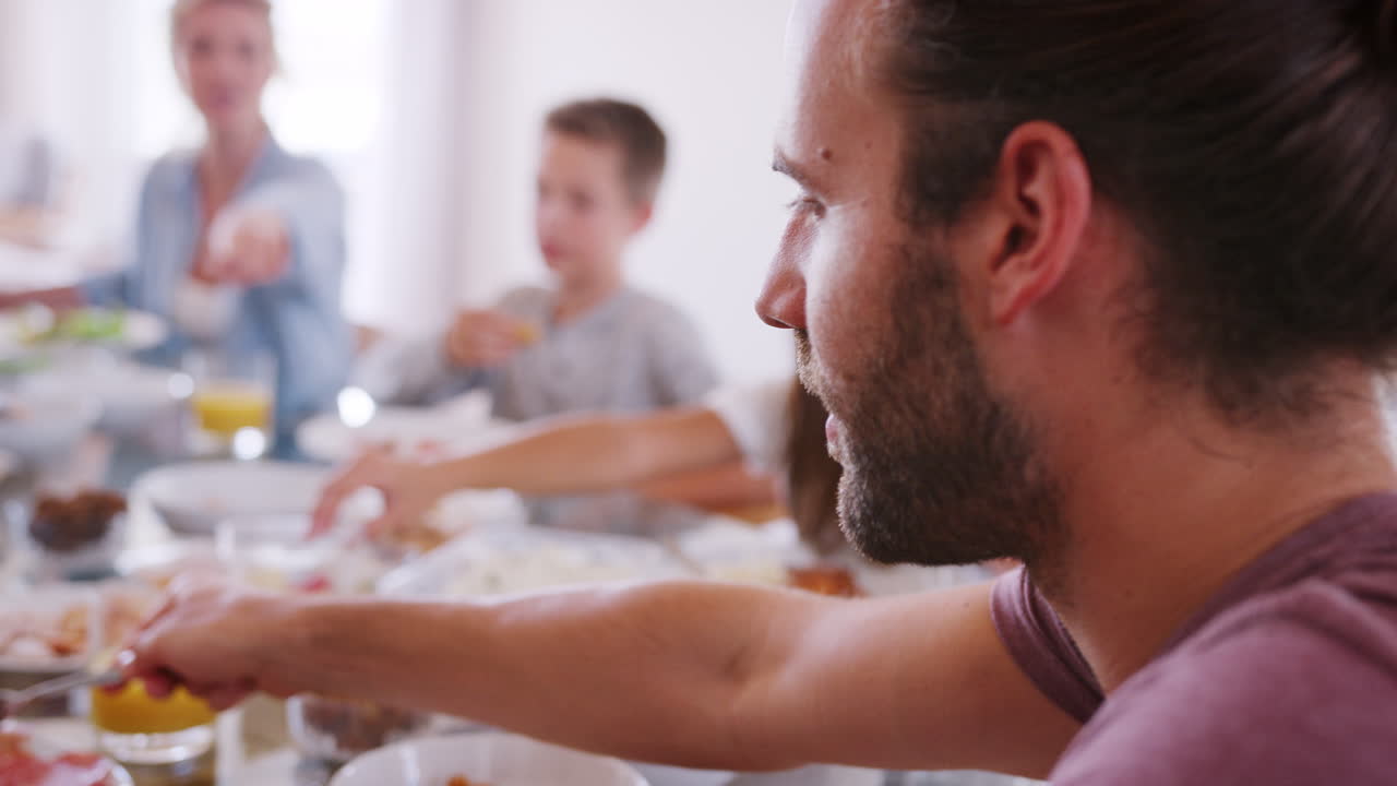 Famiglia che gusta un pasto a casa insieme, ripresa al rallentatore