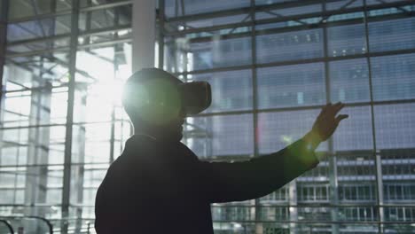 hombre de negocios usando auriculares de realidad virtual en el vestíbulo de la oficina 4k