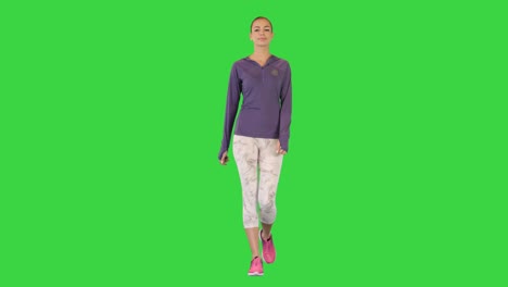 cute fitness woman having a walk on a green screen, chroma key