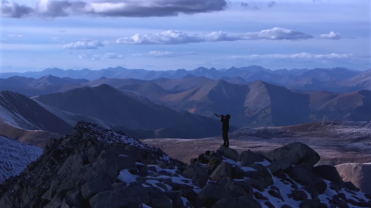 Shofar ram horn music blown from hiker top of Rocky Mountains summit Jewish Christian tradition Walls of Jericho Mt Mount Shavano Elbert Huron Peak Central Colorado aerial drone sunset snow parallax