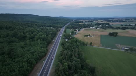 an aerial view of traffic on a highway in the late evening light with the last color of the sunset leaving the sky