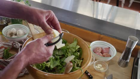 cutting the cheese into the salad