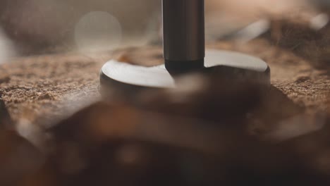 super close up of wood shavings flying out from drill bit, sawdust