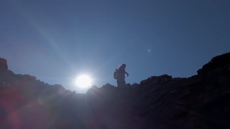 Hiker-pointing-to-distance-on-top-of-mountain-low-angle-approached-Kananaskis-Alberta-Canada