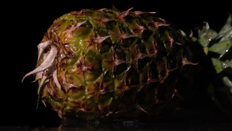 Pineapple-falling-and-splitting-on-black-background