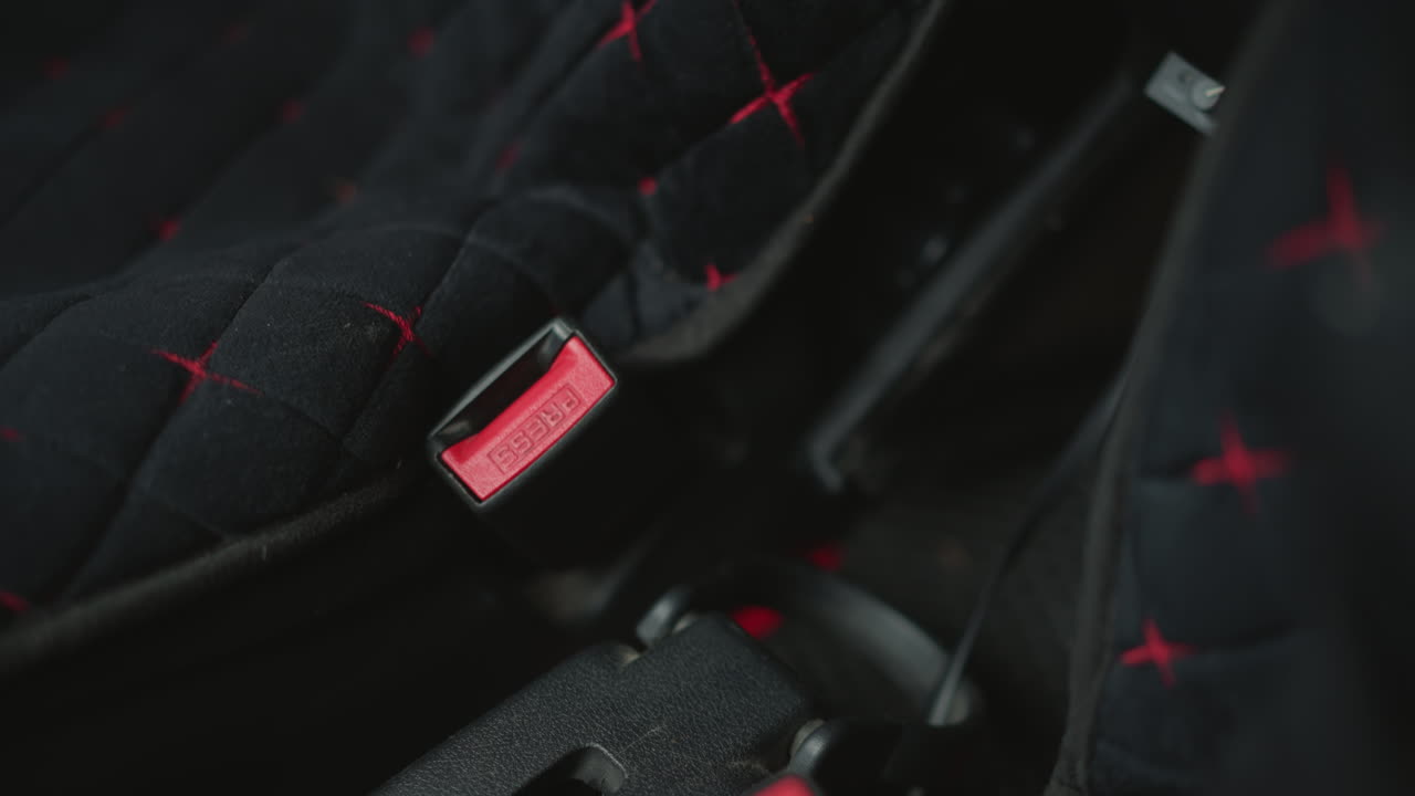 Hand view of motorist adjusting seat belt strap over shoulder inside car cabin intimate focus on hand movement securing latch and buckle for safety before cold urban commute drive