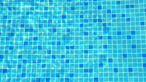 small blue tiles on the swimming pool floor