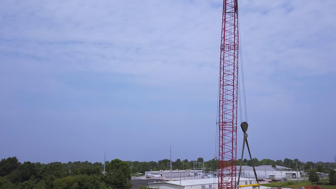 Ascending aerial view of construction crane on job site