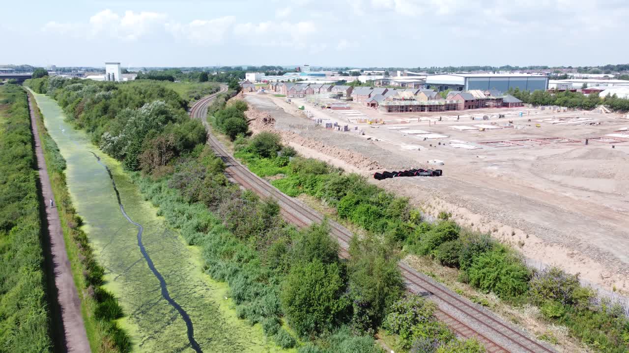 새 주택 건설 현장과 함께 녹조류로 덮인 시골 운하가 오른쪽으로 회전하는 조감도