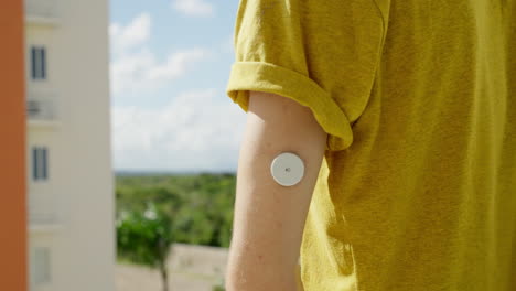 hombre adulto joven comprobando sus niveles de glucosa en sangre en el brazo izquierdo con el sensor freestyle libre 2