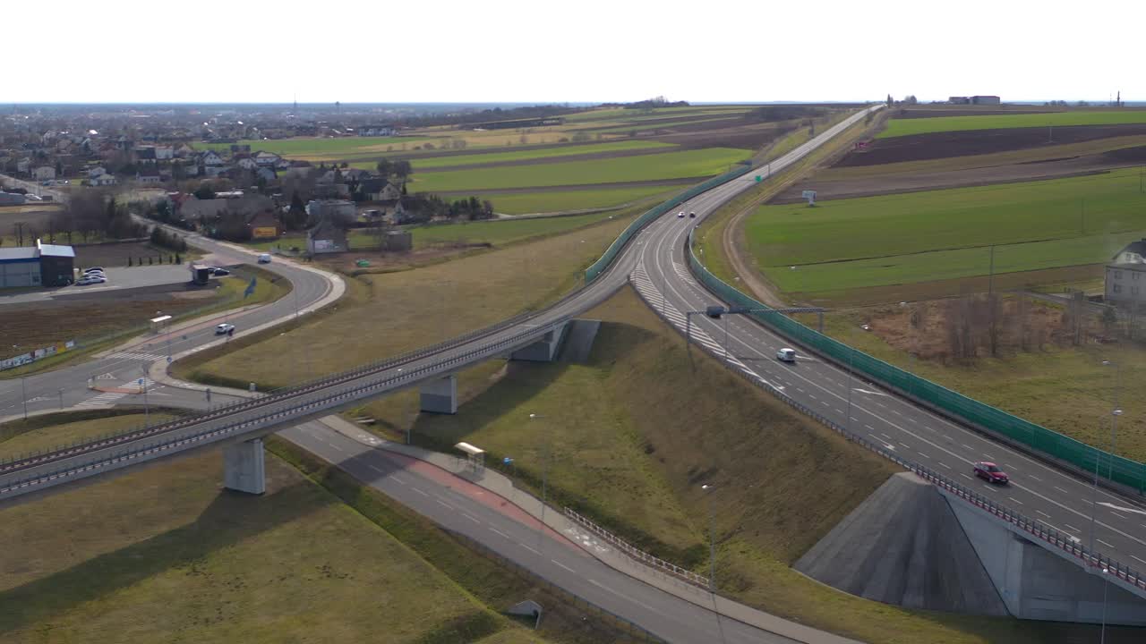 Aerial wide angle fly by shot of the vehicles on a highway on a bright sunny afternoon