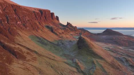 desmoronándose acantilados inclinados y puntiagudos de deslizamiento de tierra geológico bañado en la luz del amanecer en invierno