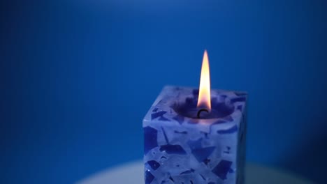 a lit blue candle was spinning in a christmas wreath