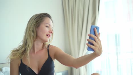 woman taking selfie and having a video call in her bedroom.