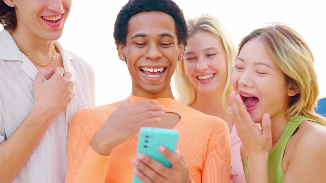 Group of friends laughing while looking at a mobile phone