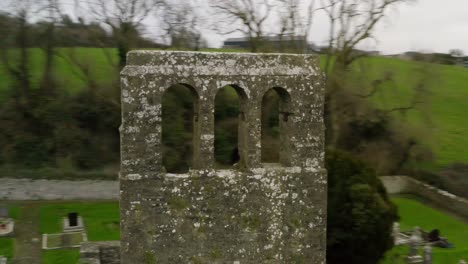 Drone-orbits-around-weathered-bell-tower-of-concrete-bricks-with-no-bell