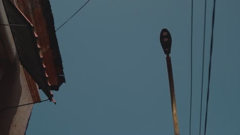 cinematic, artistic shot of street lighting pole between two houses