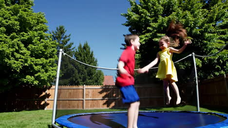 children jumping on a trampoline in the backyard