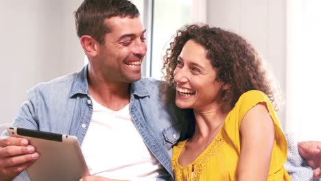 Cute-couple-using-tablet-computer-on-the-couch