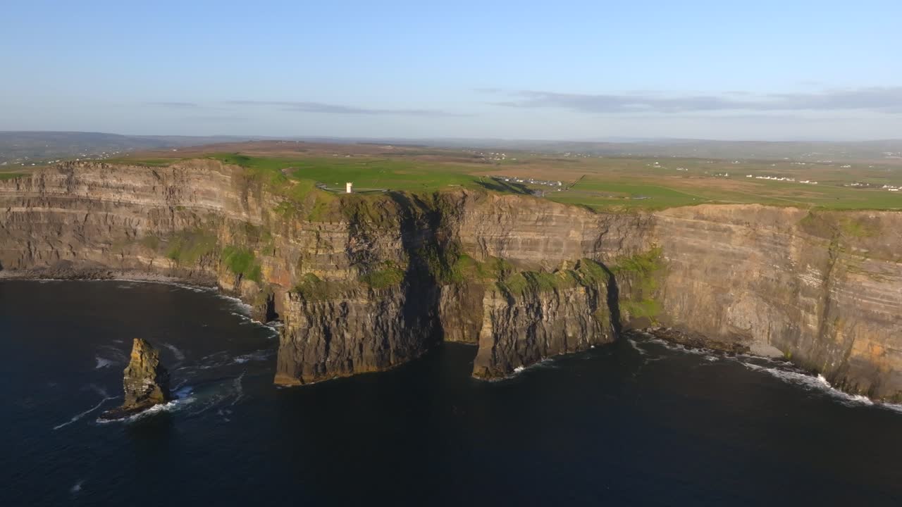 Cliffs of Moher, County Clare, Ireland, May 2025. Drone orbits clockwise around iconic cliffs meet vast Atlantic in epic coastal nature at golden hour under clear blue skies.