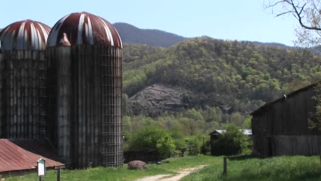 Große-Getreidesilos-Und-Die-Umliegenden-Berge-Prägen-Das-Landschaftsbild-Dieses-Bäuerlichen-Hofes