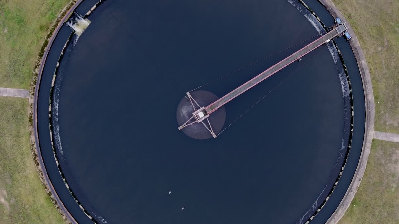 야외에 위치한 둥근 폐수 처리 시설을 포착하는 공중 촬영.