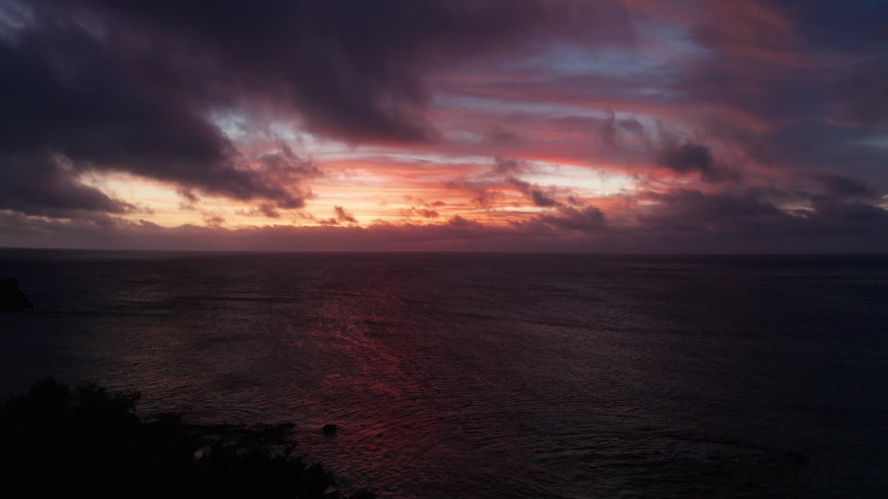The beautiful fiery red sunset under dark purple sky, a stunning view from the Fiji Islands - aerial