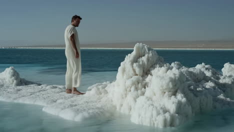 man standing on salt flats in a desert landscape