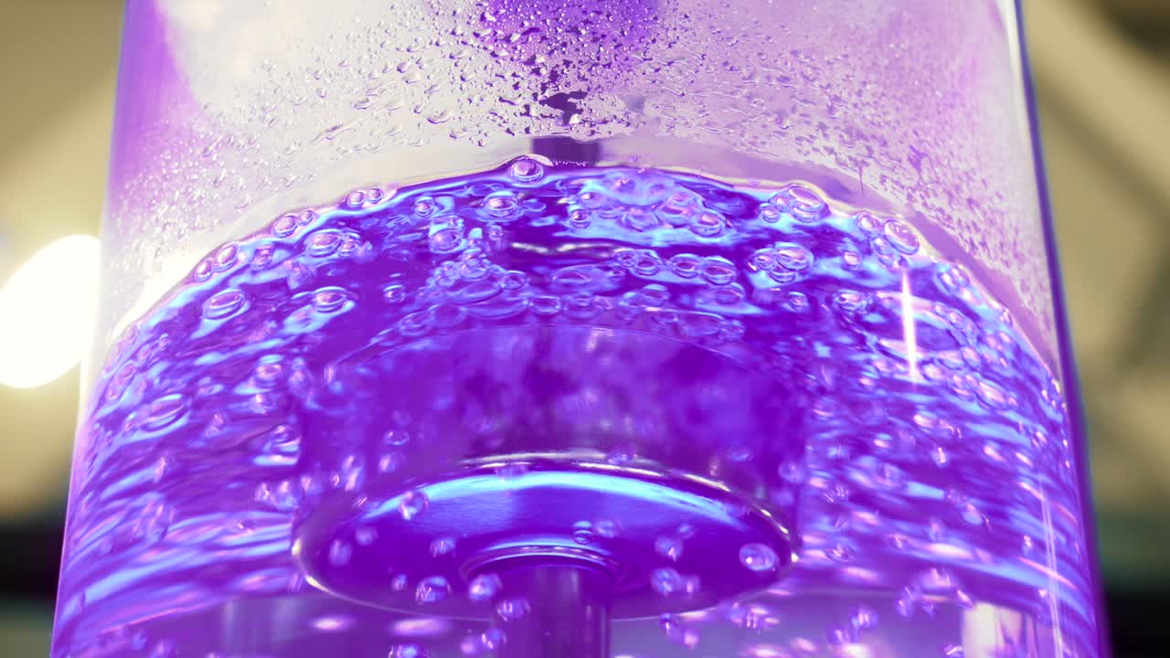 líquido púrpura con burbujas en un dispensador