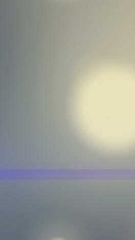 animation of blue spotlight with lens flare over bokeh light spots on grey