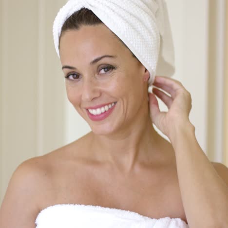 Woman-wrapped-in-towel-smiles-at-camera