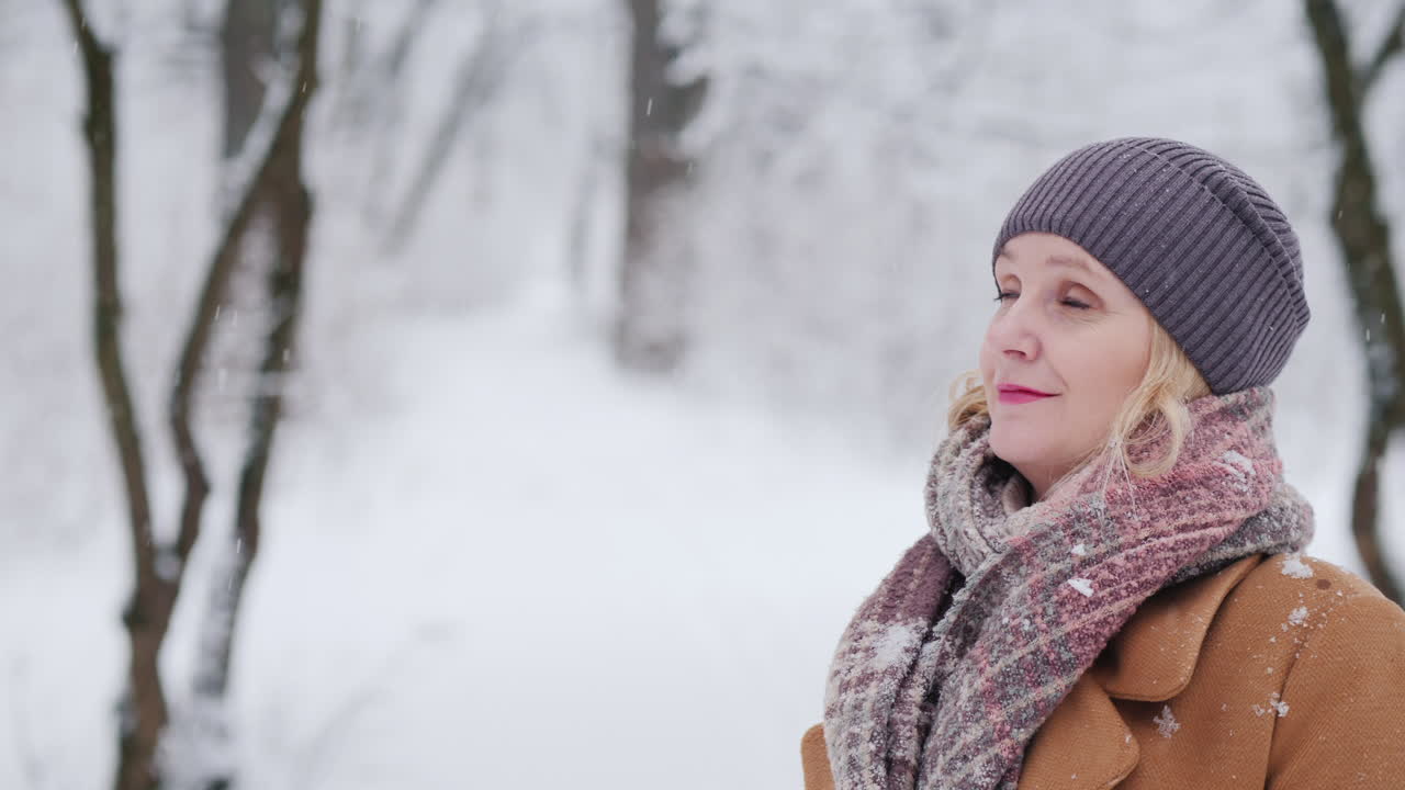 겨울 공원에 있는 중년 여성의 초상화가 카메라 4k 비디오를 들여다본다