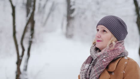 portrait of a middle-aged woman in a winter park looks into the camera 4k video