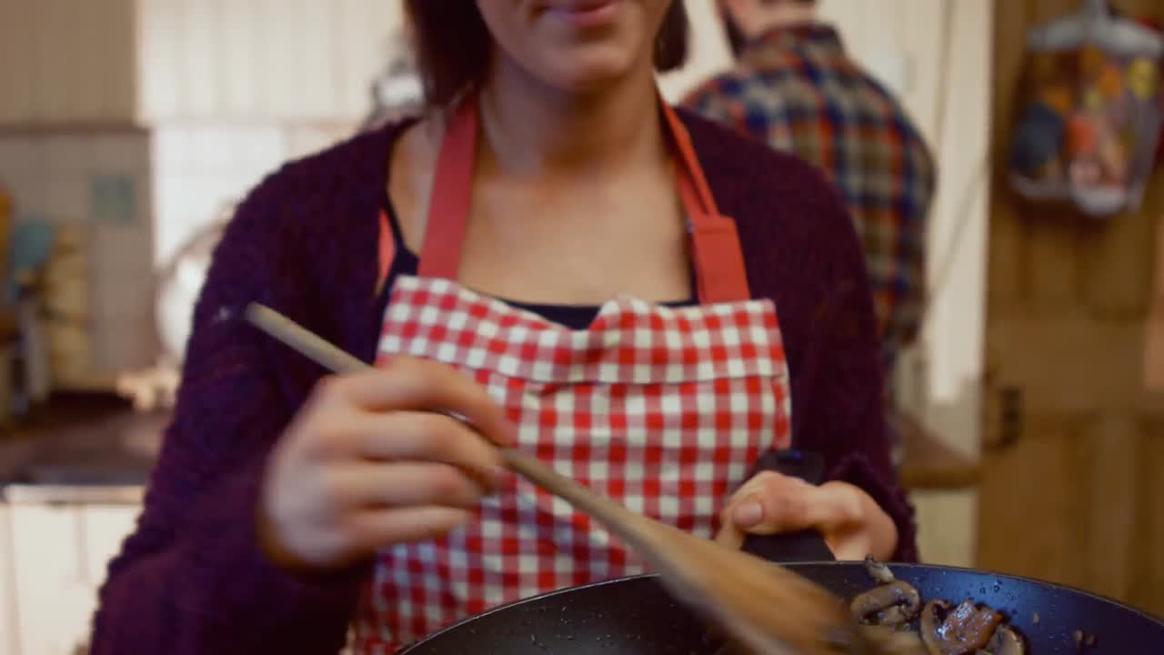 mujer sonriente cocinando comida en la cocina