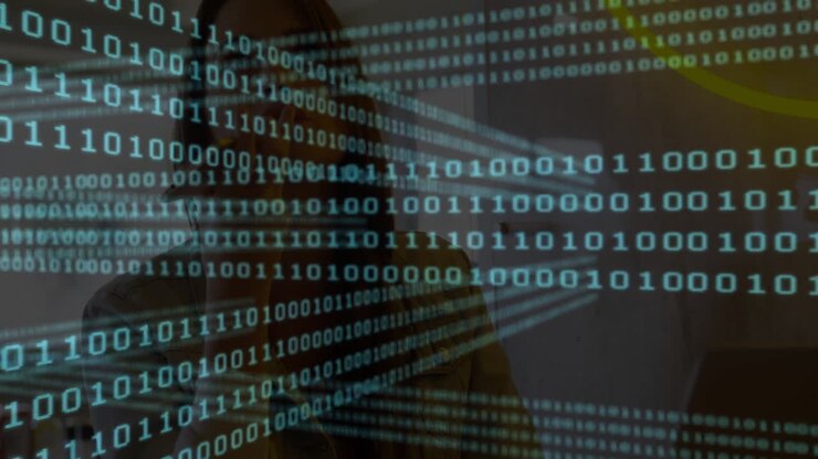 In school, person working on computer with binary code animation overlaying screen