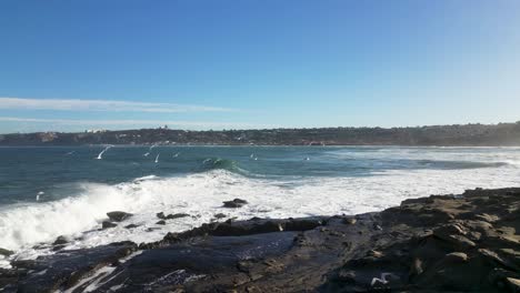 4K-Zeitlupenaufnahmen-Von-Großen-Meereswellen,-Die-Bei-Flut-In-La-Jolla-Cove-In-San-Diego,-Kalifornien,-Auf-Klippen-Krachen,-Während-Weiße-Vögel-Kreisen