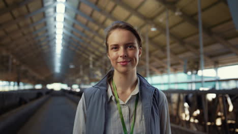 mujer sonriente posando en el pasillo del cobertizo sola retrato. especialista agrícola en el trabajo.