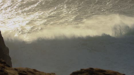 golden sunset with big waves breaking at nazare
