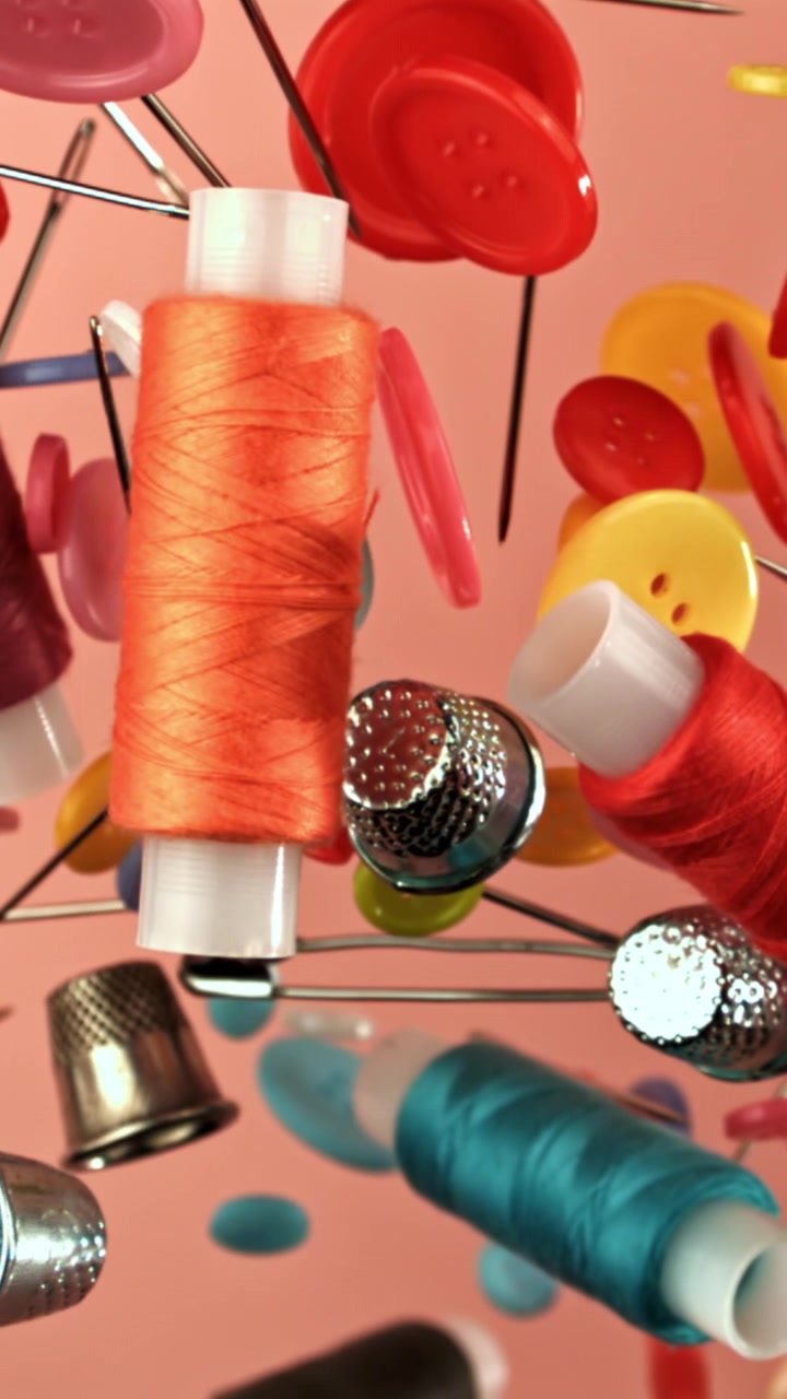 Colorful Sewing Supplies Floating Against a Pink Background