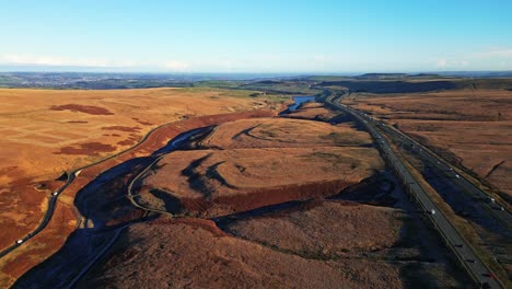 Alta-Vista-Aérea-De-Los-Páramos-De-Saddleworth-Moor,-La-Autopista-M62-Y-La-Carretera-Ripponden