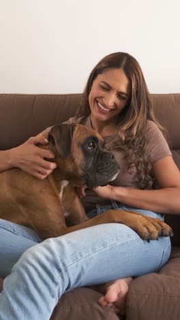 happy woman with boxer dog watching tv in modern apartment
