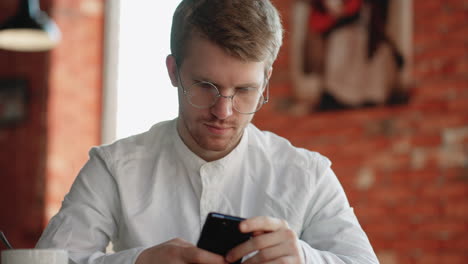 serious-man-is-reading-financial-news-in-smartphone-sitting-in-cafe-in-morning-doomscrolling-and-doomsurfing