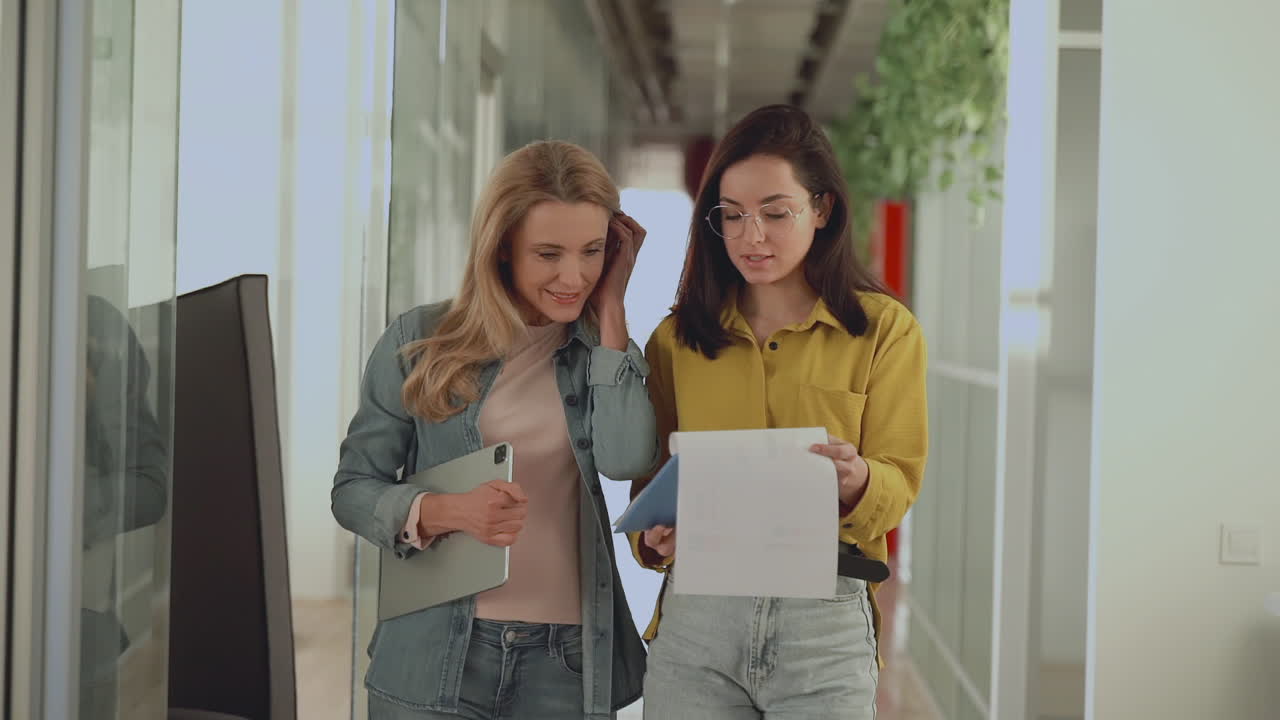 International Women's Day. Business females walking towards the camera in a corridor.