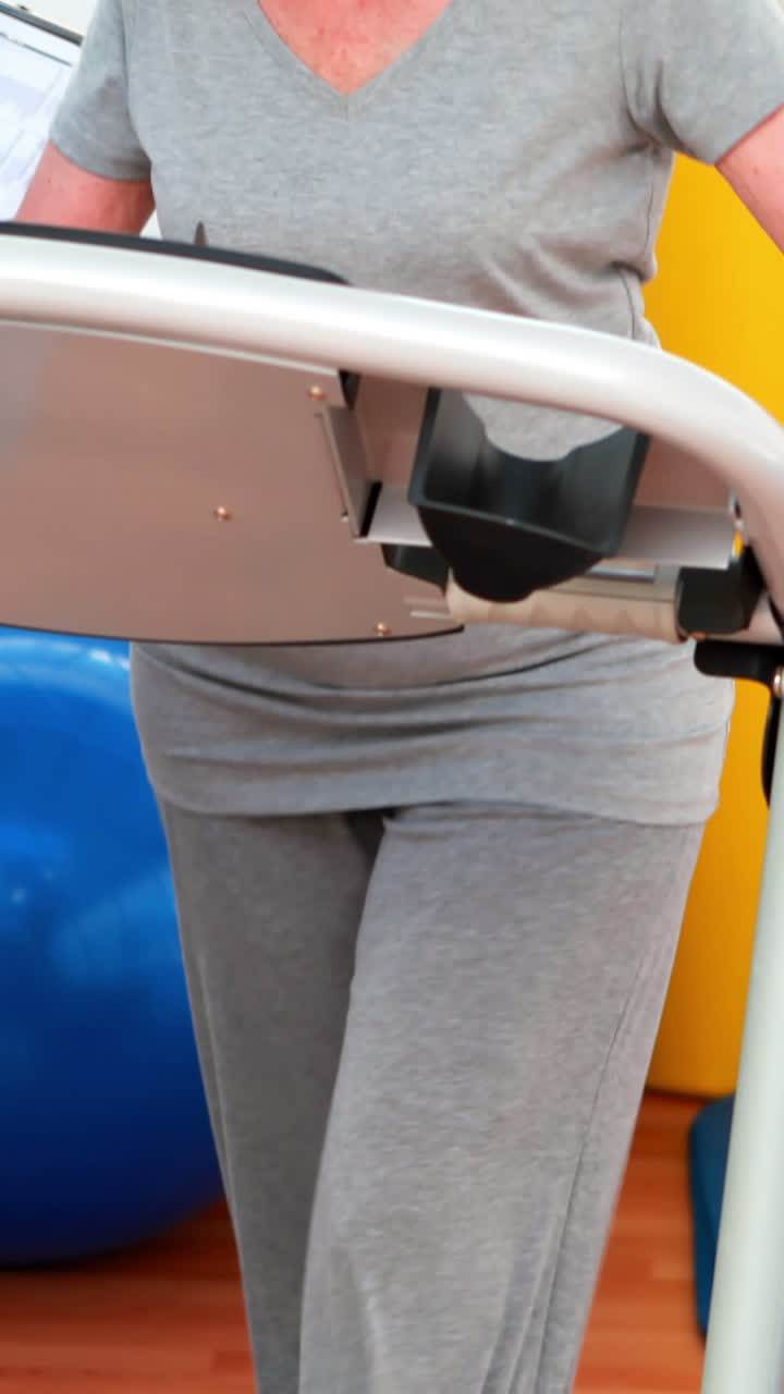 terapeuta físico mostrando al paciente cómo usar la cinta de correr