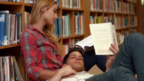 pareja revisando en la biblioteca