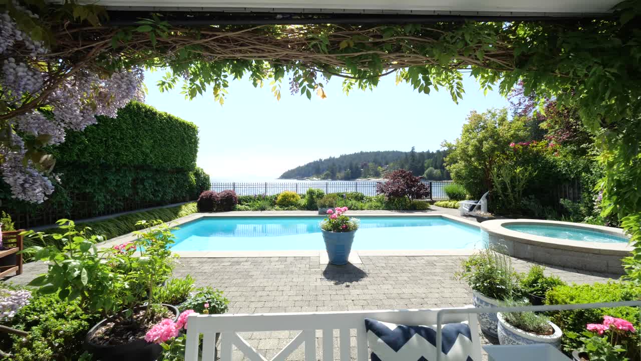 Sliding shot of beautiful home with white table and out door pool in the garden