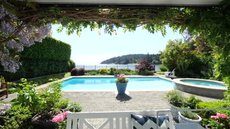 Toma-Deslizante-De-Una-Hermosa-Casa-Con-Mesa-Blanca-Y-Piscina-Al-Aire-Libre-En-El-Jardín